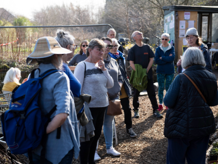 A group of individuals listen to the leader of a PCHP walk.