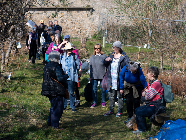 A group of individuals walking along a path to a Walk Leader at a PCHP community event.