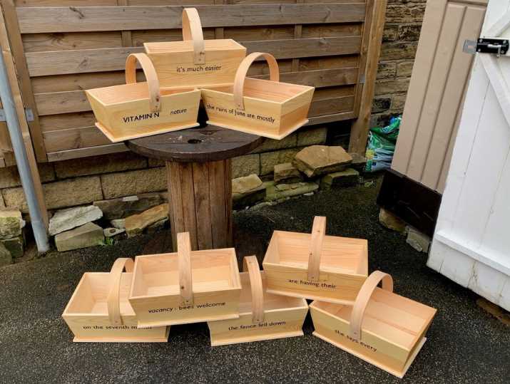 A collection of wooden garden baskets with poems written on them.