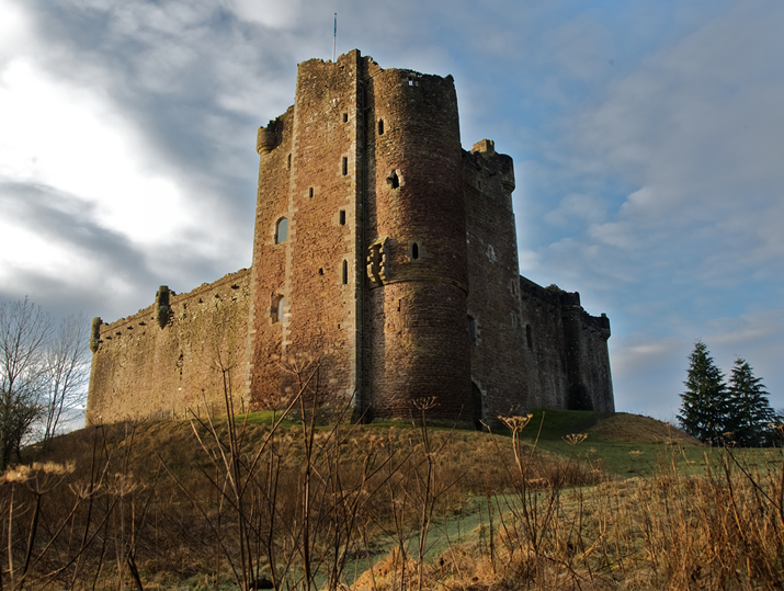 Doune Castle standing on grassy hill at dusk Visit Scotland