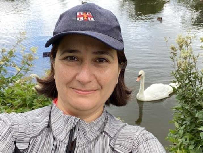 Professer Gozde Ozakinci - University of Stirling in front of a pond with a swan behind her.