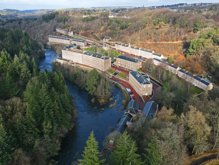 aerial view of UNESCO World Heritage site New Lanark with clyde falls and forest