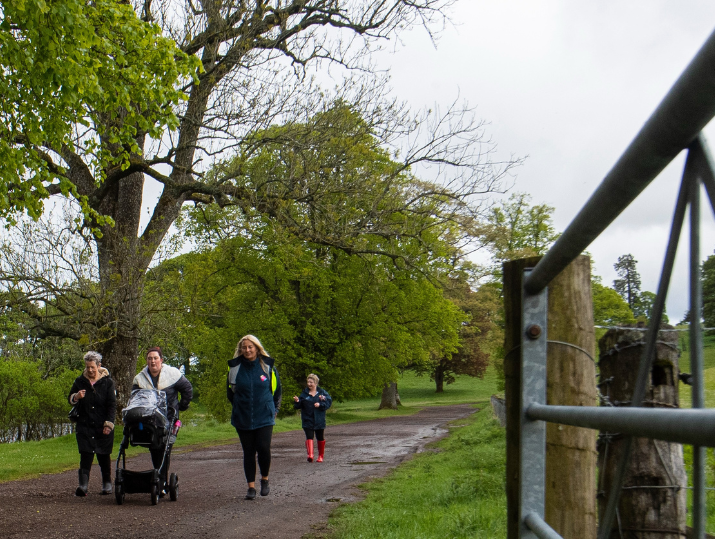 A group of walkers talk as they walk along a path as part of a Healthy Valleys Health Walk.
